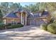 Elegant brick home with a large driveway and three-car garage nestled among mature trees at 4763 River Hills Dr, Denver, NC 28037