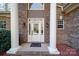 Elegant brick home entrance framed by large white columns and a glass-paneled door with sidelights and transom window at 4763 River Hills Dr, Denver, NC 28037