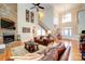 Bright living room features a stone fireplace, hardwood floors, elegant staircase, and large windows with a grand chandelier at 4763 River Hills Dr, Denver, NC 28037