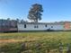 A ranch style home with white siding, a metal roof, and a large front yard at 485 Harper Miller Dr, Cleveland, NC 27013