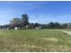 Beautiful property featuring a well-maintained lawn, home, outbuilding, and a serene, tree-lined backdrop under a clear blue sky at 485 Harper Miller Dr, Cleveland, NC 27013