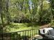 Spacious backyard with lush green grass, mature trees, and a wrought iron fence at 5057 Murrayhill Rd, Charlotte, NC 28210