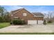 Spacious three-car garage featuring a brick exterior and ample driveway space, providing convenient parking at 518 Streamside Ln, Marvin, NC 28173