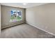The bedroom has neutral walls, carpet, and a large window bringing in lots of natural light at 5810 Dove Point Sw Dr, Concord, NC 28025