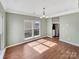 The dining room features hardwood floors, large windows, and an elegant chandelier, perfect for Gathering dinners at 5810 Dove Point Sw Dr, Concord, NC 28025