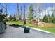 A backyard featuring a stone patio, a charming landscape, and a treelined border for privacy at 6016 Dogwood Blvd, Kannapolis, NC 28081
