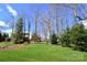 Spacious backyard with a vibrant green lawn, mature trees, and a charming wooden playset for Gathering fun at 6016 Dogwood Blvd, Kannapolis, NC 28081
