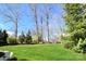Large backyard featuring a lush green lawn, mature trees, and a playground for outdoor enjoyment at 6016 Dogwood Blvd, Kannapolis, NC 28081
