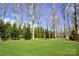 Well-maintained backyard with a manicured lawn, mature trees, and a small shed, providing a serene outdoor space at 6016 Dogwood Blvd, Kannapolis, NC 28081