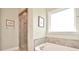 Bathroom featuring a soaking tub, tiled shower with glass door, and ample natural light from a window at 6016 Dogwood Blvd, Kannapolis, NC 28081