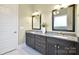 Bathroom featuring double vanity with granite countertops, dark wood cabinetry, and modern fixtures at 6016 Dogwood Blvd, Kannapolis, NC 28081