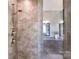 Modern tiled shower with glass door, rainfall shower head, and view into a bathroom with a granite vanity at 6016 Dogwood Blvd, Kannapolis, NC 28081