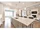 Open concept kitchen featuring a large island with seating, hardwood floors, and an open view to the living room at 6016 Dogwood Blvd, Kannapolis, NC 28081