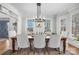 Bright dining room with wood table, white chairs, modern chandelier, and views to the outside at 607 Beaten Path Rd, Mooresville, NC 28117