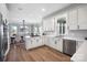 Gourmet kitchen with white cabinets, stainless steel appliances, quartz countertops, and hardwood floors at 607 Beaten Path Rd, Mooresville, NC 28117