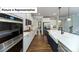 Modern kitchen with stainless steel appliances, white cabinets, and an expansive island with seating at 7021 Sylvan Retreat Dr, Denver, NC 28037