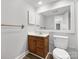 Well-lit bathroom with a wood vanity, white toilet, and a large framed mirror at 7415 Mystic Ln, Charlotte, NC 28227