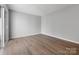 Large bedroom with neutral paint, wood-look floors, and sliding glass door at 7415 Mystic Ln, Charlotte, NC 28227