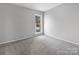 Bedroom featuring plush carpeting, neutral paint, and a sunny window with a view at 7415 Mystic Ln, Charlotte, NC 28227