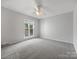 Spacious bedroom featuring neutral colors, carpeting, a ceiling fan, and a window view at 7415 Mystic Ln, Charlotte, NC 28227