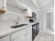 Well-lit kitchen with stainless steel sink, white cabinets, and black appliances at 7415 Mystic Ln, Charlotte, NC 28227