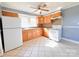 Well-lit kitchen featuring wooden cabinets, white appliances, and tile flooring at 826 E Alexander St, Lincolnton, NC 28092