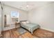 Sunlit bedroom with wood floors features a bed, side table and area rug at 9018 Seamill Rd, Charlotte, NC 28278