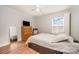 Simple bedroom with wood floors features a bed, dresser and decor mirror at 9018 Seamill Rd, Charlotte, NC 28278