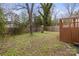 This sprawling backyard includes a wooden deck and fence, and mature trees for shade at 98 Ring Sw Ave, Concord, NC 28025