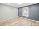 This bedroom features stylish gray accent wall, a window for natural light, and modern light-colored flooring at 98 Ring Sw Ave, Concord, NC 28025