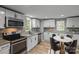 Bright kitchen with stainless appliances, granite countertops, mosaic backsplash, and breakfast table at 98 Ring Sw Ave, Concord, NC 28025
