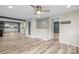 Open-concept living room featuring modern ceiling fan, tiled accent wall, and durable wood-look floors at 98 Ring Sw Ave, Concord, NC 28025