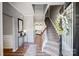 Bright foyer featuring hardwood floors, a staircase with wood railing, and a decorative glass front door at 10153 Elizabeth Crest Ln, Charlotte, NC 28277