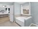 Bright bathroom featuring a tub under a window, and a partial view into a bedroom at 10605 Three Rivers Ct, Charlotte, NC 28273