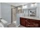 Modern bathroom features a glass shower, double vanity, and brown cabinets at 10605 Three Rivers Ct, Charlotte, NC 28273