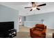 An upstairs bonus room features a ceiling fan and a comfy leather chair at 10605 Three Rivers Ct, Charlotte, NC 28273