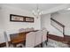 Formal dining room featuring a modern chandelier, large table and staircase in the background at 10605 Three Rivers Ct, Charlotte, NC 28273