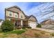 A view of a two-story home with a two car garage, well-maintained lawn, and a welcoming porch at 10605 Three Rivers Ct, Charlotte, NC 28273