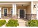 Covered front porch with stone accents, modern lighting, house number and black front door at 10605 Three Rivers Ct, Charlotte, NC 28273
