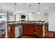 Kitchen with stainless steel dishwasher, tile backsplash, and brown cabinets at 10605 Three Rivers Ct, Charlotte, NC 28273
