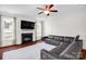 Spacious living room featuring a cozy fireplace, large windows, and a gray leather sofa at 10605 Three Rivers Ct, Charlotte, NC 28273