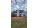 View of back exterior with a brick patio, light siding, and well-maintained landscaping at 10607 Old Bridge Ln, Charlotte, NC 28269