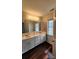 Bright bathroom featuring double vanity, tiled accent wall, and wood-look floors at 10607 Old Bridge Ln, Charlotte, NC 28269