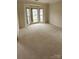 Large living room featuring neutral carpeting, ample natural light, and great proportions at 10607 Old Bridge Ln, Charlotte, NC 28269