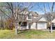 Charming two-story home with a brick and siding exterior, covered porch, and attached garage at 10820 Hunters Trace Ct, Charlotte, NC 28262