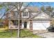 Charming two-story home with a brick and siding exterior, covered porch, and attached garage at 10820 Hunters Trace Ct, Charlotte, NC 28262