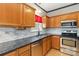Well-lit kitchen featuring stainless steel appliances, granite countertops, and wood cabinets at 10820 Hunters Trace Ct, Charlotte, NC 28262