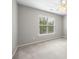 Bedroom featuring neutral carpet, ceiling fan, and a large window at 10933 Sedgemoor E Ln, Charlotte, NC 28277
