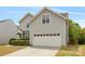 A home featuring an attached two-car garage and complementing stone and siding exterior at 10933 Sedgemoor E Ln, Charlotte, NC 28277