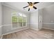 Inviting living room featuring hardwood floors, a ceiling fan, and a large window offering ample natural light at 10933 Sedgemoor E Ln, Charlotte, NC 28277